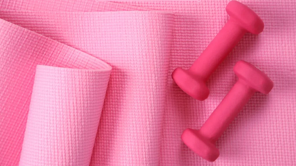 Pink yoga mat with light dumbbells for best Somatic Pilates apps.
