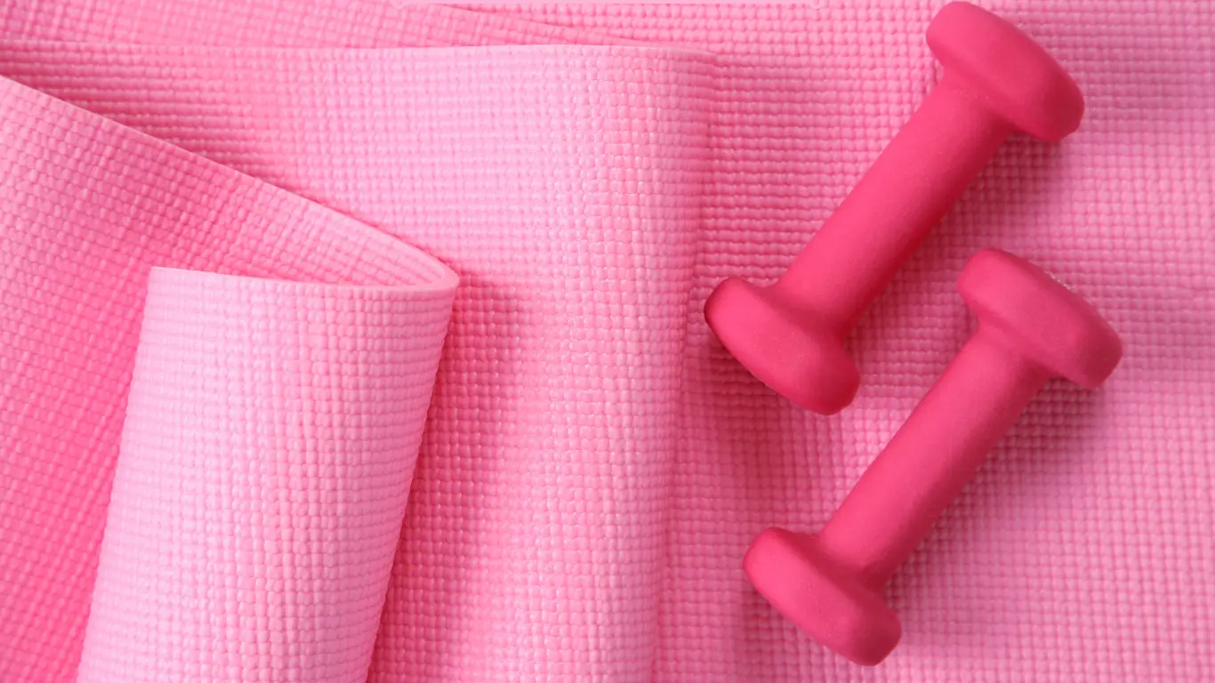 Pink yoga mat with light dumbbells for best Somatic Pilates apps.