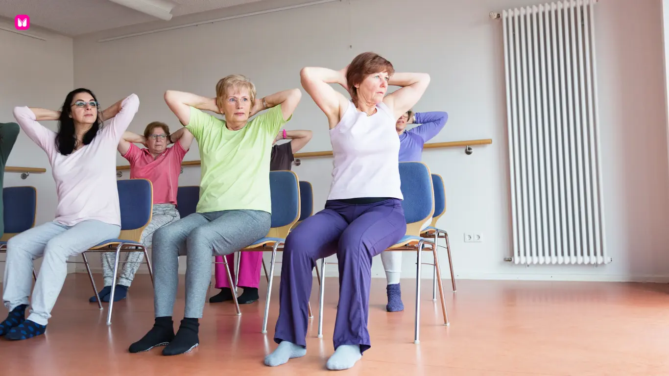 Seniors practicing seated chair yoga twist in a group class